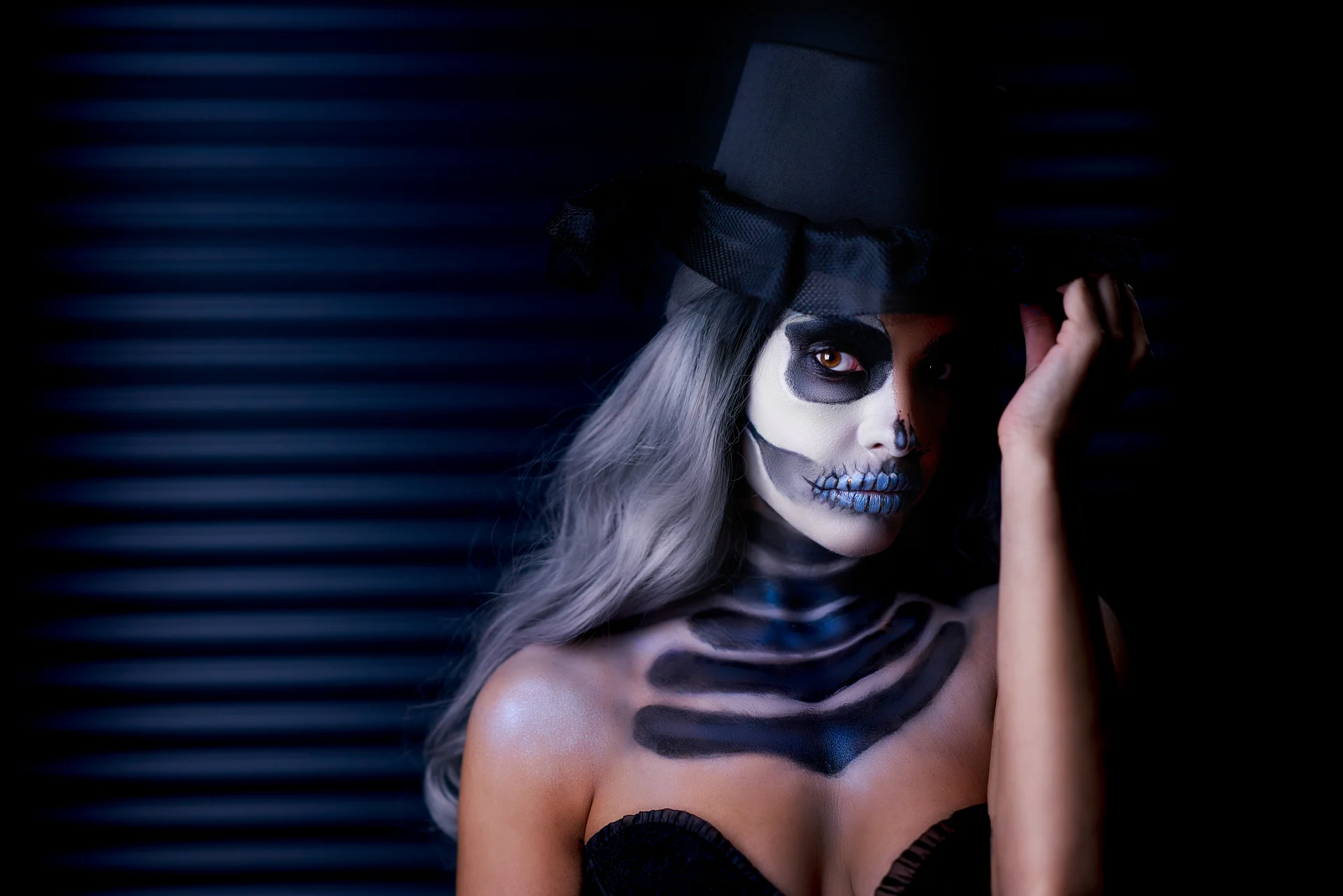 Woman in skeleton body paint and a top hat for Halloween