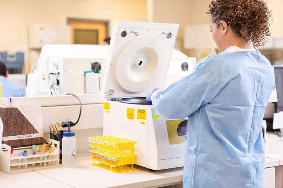 Scientist Using PCR Testing Machine In Laboratory