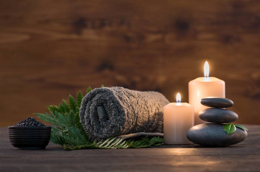 Towel, Candles, and Black Stones in a Relaxing Room